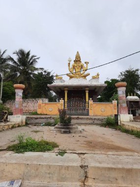Channapatna, Karnataka, Hindistan-Aug 15 2021: Güzel eski Sri Arkeshwara Tapınağı Altın Renkli Shiva heykelinin yakın çekimi, Bevoor tapınağının tepesinde, Gölet 'in yanında