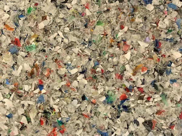 カラフルなリサイクル細断されたプラスチック片の背景や背景の閉鎖 — ストック写真
