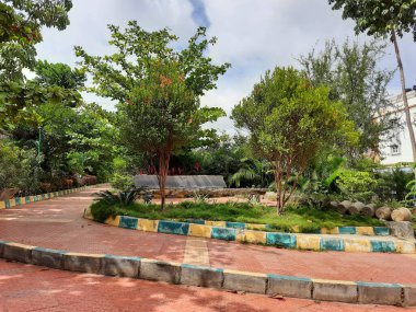 Güzel halka açık sabah ve akşama yakın park içinde yürüyüş yolları iyi bakımlı, kaya veya taş sandalyeler Bangalore şehrinde oturmak için