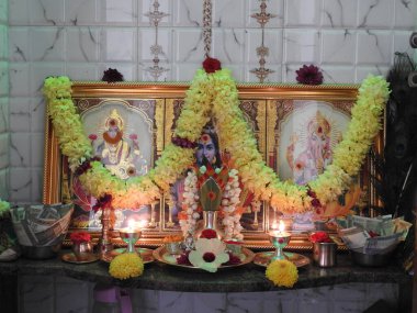 Bangalore, Karnataka, Hindistan-Aug 20, 21: Güzel dekore edilmiş tanrıların odası ve çelenkli Lord fotoğrafları, para notları, sikkeler