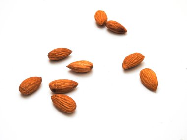 Beyaz arka planda izole edilmiş bir sürü badem tohumu yığını.