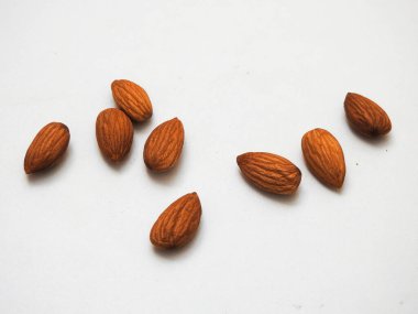 Beyaz arka planda izole edilmiş bir sürü badem tohumu yığını.