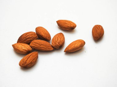 Beyaz arka planda izole edilmiş bir sürü badem tohumu yığını.