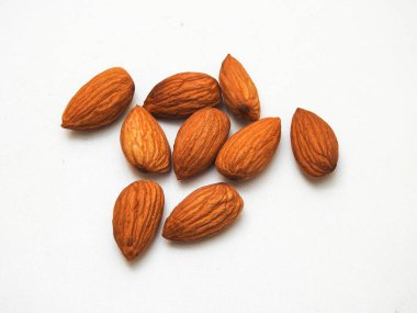 Beyaz arka planda izole edilmiş bir sürü badem tohumu yığını.