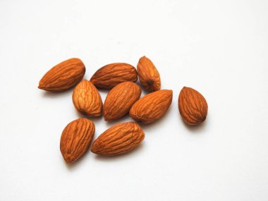 Beyaz arka planda izole edilmiş bir sürü badem tohumu yığını.