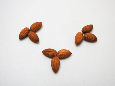 Beyaz arka planda izole edilmiş bir sürü badem tohumu yığını.