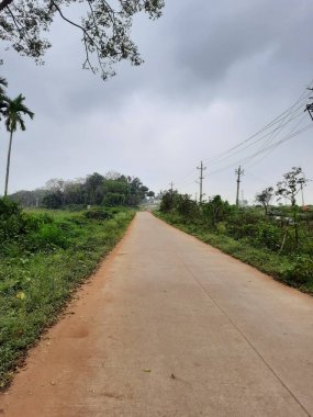 Bangalore, Karnataka, India-Dec 15, 2021: Closeup of beautiful asphalt and sand road in a rural with nature background