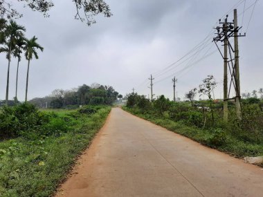 Bangalore, Karnataka, India-Dec 15, 2021: Closeup of beautiful asphalt and sand road in a rural with nature background