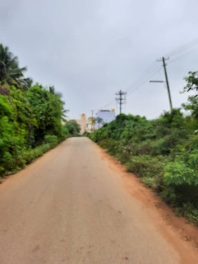 Bangalore, Karnataka, India-Dec 15, 2021: Closeup of beautiful asphalt and sand road in a rural with nature background