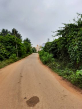 Bangalore, Karnataka, India-Dec 15, 2021: Closeup of beautiful asphalt and sand road in a rural with nature background