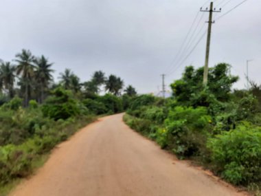 Bangalore, Karnataka, India-Dec 15, 2021: Closeup of beautiful asphalt and sand road in a rural with nature background