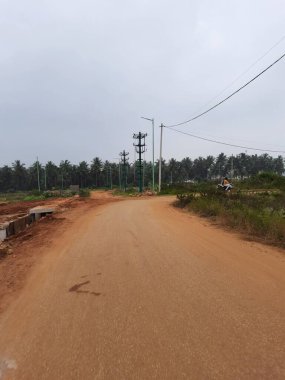 Bangalore, Karnataka, India-Dec 15, 2021: Closeup of beautiful asphalt and sand road in a rural with nature background