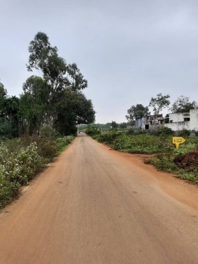 Bangalore, Karnataka, India-Dec 15, 2021: Closeup of beautiful asphalt and sand road in a rural with nature background