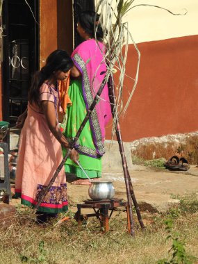 Bangalore, Karnataka, Hindistan-15 Ocak 2022: Makara Sankranti Festivali 'ni kutlayan ve evin dışında pongal yapan Hintli şirin aileye yakın çekim.