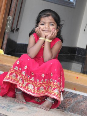 Bangalore, Karnataka, Hindistan-15 Ocak 2022: Geleneksel olarak Makara Sankranti veya Pongal Prasada 'yı komşulara dağıtmak için giydirilmiş güzel Hintli kız çocuğuna yakın çekim.