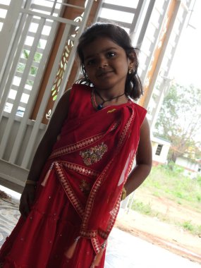 Bangalore, Karnataka, Hindistan-15 Ocak 2022: Geleneksel olarak Makara Sankranti veya Pongal Prasada 'yı komşulara dağıtmak için giydirilmiş güzel Hintli kız çocuğuna yakın çekim.