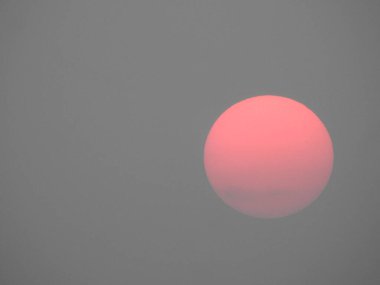 Gökyüzü arka planında güzel kırmızı ve pembe renkli Güneş 'in yakın çekimi