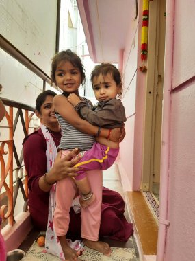 Bangalore, Karnataka, Hindistan-13 Şubat 2022: Küçük bir çocuğu kucağında tutan Hintli kız çocuğu.