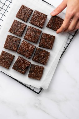 Beyaz mermer arka plan manzaralı çikolatalı kek. Uzayı elinde bir parçayla kopyala.