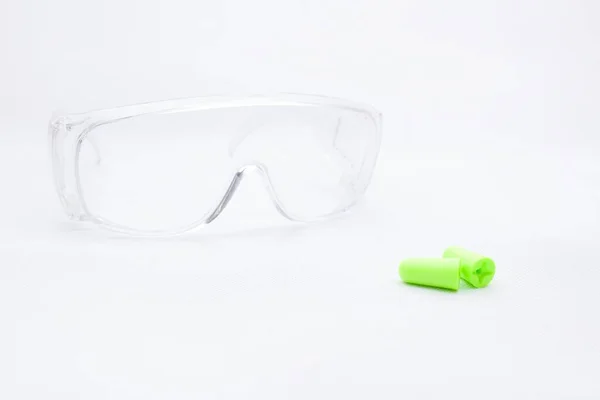 防护设备 防噪音的耳塞和在白色背景上隔离的透明塑料护目镜听力保护 在嘈杂的环境中的必要性 — 图库照片