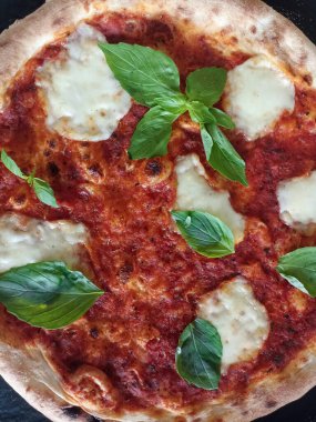 İtalyan spesiyali, mozzarella soslu pizza, domates sosu ve fesleğen. Fırından yeni çıkmış taze ve çıtır çıtır..