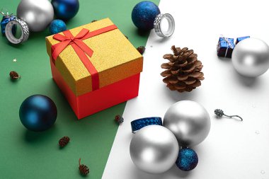 Konili Noel kompozisyonu, Noel topları ve parlak iki renkli arka planda bir hediye kutusu.