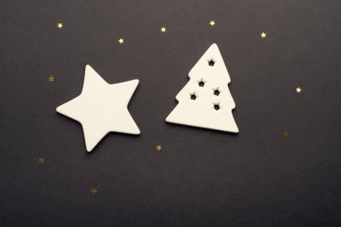 Beyaz yıldız ve yıldızlı bir arka planda seramikten yapılmış Noel ağacı