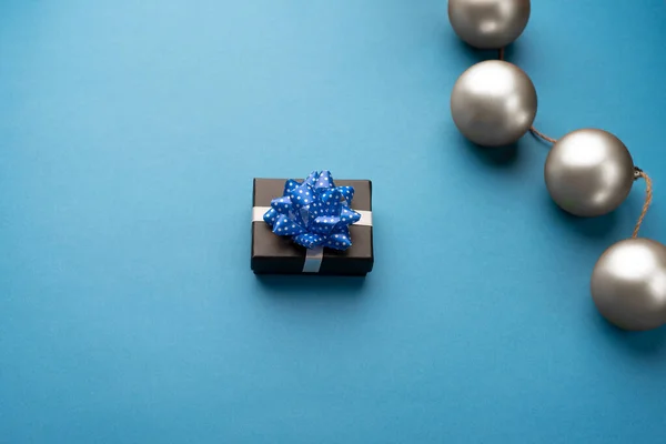 Małe Pudełko Niebieską Wstążką Świąteczne Kulki Jasnoniebieskim Tle — Zdjęcie stockowe