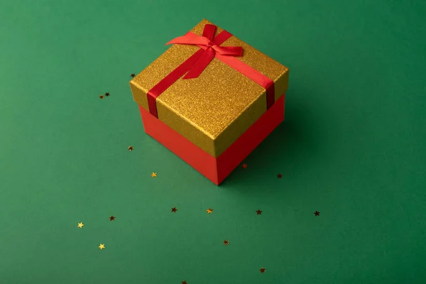 Czerwone Złote Pudełko Głębokim Zielonym Tle Złotymi Gwiazdami — Zdjęcie stockowe