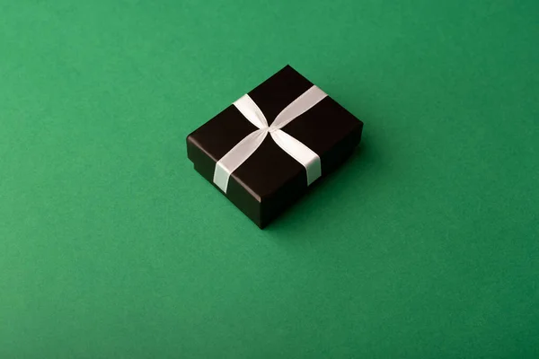 Czarne Pudełko Białą Wstążką Głębokim Zielonym Tle — Zdjęcie stockowe