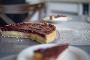 Cheesecake tepside yakın plan, bulanık arkaplan, koyu kiraz rengi üst