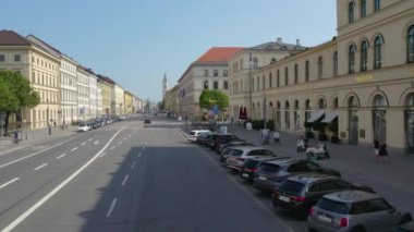 Almanya 'nın Münih şehrinde, güneşli bir yaz gününde çift katlı bir otobüsün tepesinden havadan görülen bir cadde..