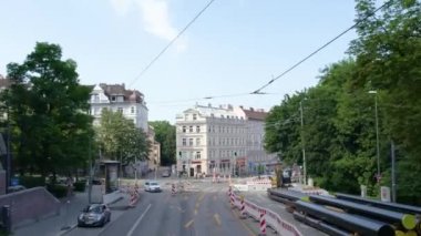 Almanya 'nın Münih şehrinde, güneşli bir yaz gününde çift katlı bir otobüsün tepesinden havadan görülen bir cadde..