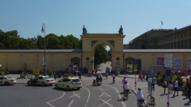 Almanya 'nın Münih şehrinde, güneşli bir yaz gününde çift katlı bir otobüsün tepesinden havadan görülen bir cadde..