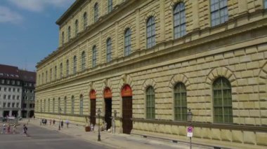 Almanya 'nın Münih şehrinde, güneşli bir yaz gününde çift katlı bir otobüsün tepesinden havadan görülen bir cadde..