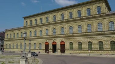 Almanya 'nın Münih şehrinde, güneşli bir yaz gününde çift katlı bir otobüsün tepesinden havadan görülen bir cadde..