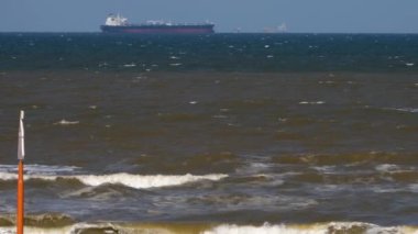 Yazın güneşli bir günde, Hollanda 'nın kumsalındaki konteynır gemisinin geniş görüşü..