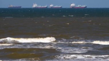 Yazın güneşli bir günde, Hollanda 'nın kumsalındaki konteynır gemisinin geniş görüşü..