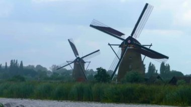 Hollanda 'da açık bir arazide yel değirmenleri Yazın bulutlu ve rüzgarlı bir günde