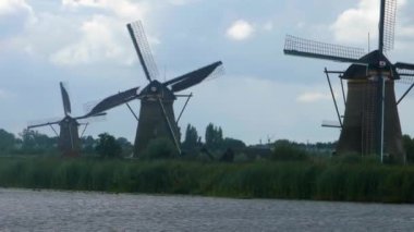 Hollanda 'da açık bir arazide yel değirmenleri Yazın bulutlu ve rüzgarlı bir günde