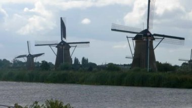 Hollanda 'da açık bir arazide yel değirmenleri Yazın bulutlu ve rüzgarlı bir günde