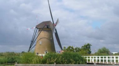 Hollanda 'da açık bir arazide yel değirmenleri Yazın bulutlu ve rüzgarlı bir günde