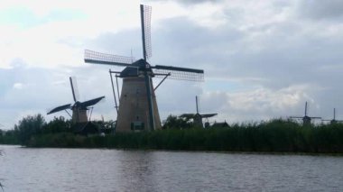 Hollanda 'da açık bir arazide yel değirmenleri Yazın bulutlu ve rüzgarlı bir günde