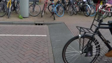 Yazın bulutlu bir günde Amsterdam şehir merkezinde bisikletler geçiyor.