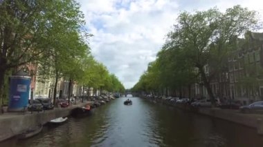  Yazın bulutlu bir günde Amsterdam 'da kumlu bir kanal manzarası