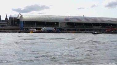 Kanallar boyunca bir tekneye binip güneşli bir günde Amsterdam 'da evler ve binaların yanında dolaşmak.. 