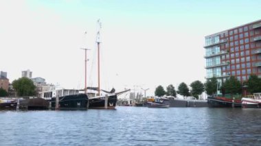 Kanallar boyunca bir tekneye binip güneşli bir günde Amsterdam 'da evler ve binaların yanında dolaşmak.. 