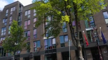 Kanallar boyunca bir tekneye binip güneşli bir günde Amsterdam 'da evler ve binaların yanında dolaşmak.. 