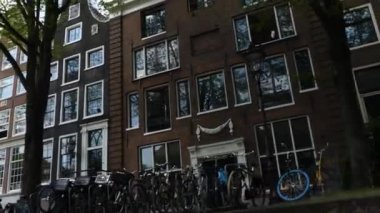 Kanallar boyunca bir tekneye binip güneşli bir günde Amsterdam 'da evler ve binaların yanında dolaşmak.. 