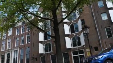 Kanallar boyunca bir tekneye binip güneşli bir günde Amsterdam 'da evler ve binaların yanında dolaşmak.. 